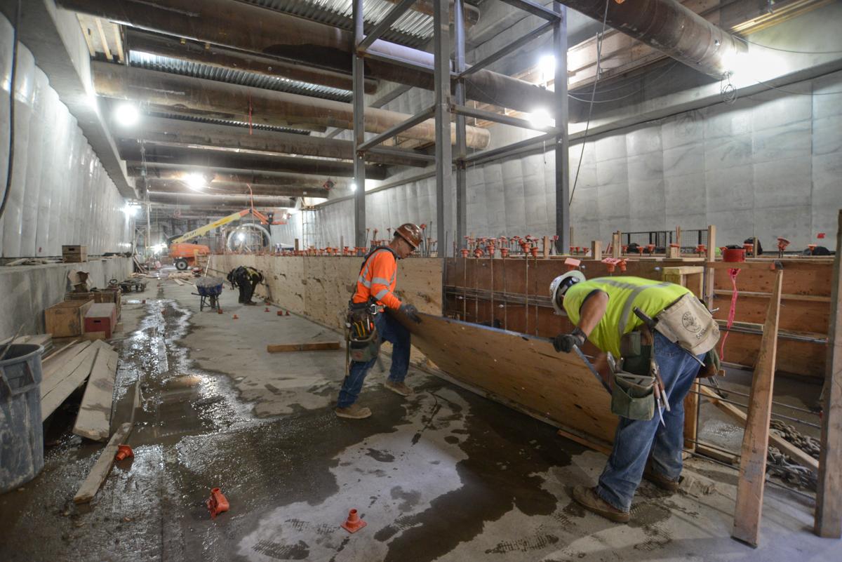 Construction workers install concrete forms and rebar for Union Square/Market Street station platform foundation walls.