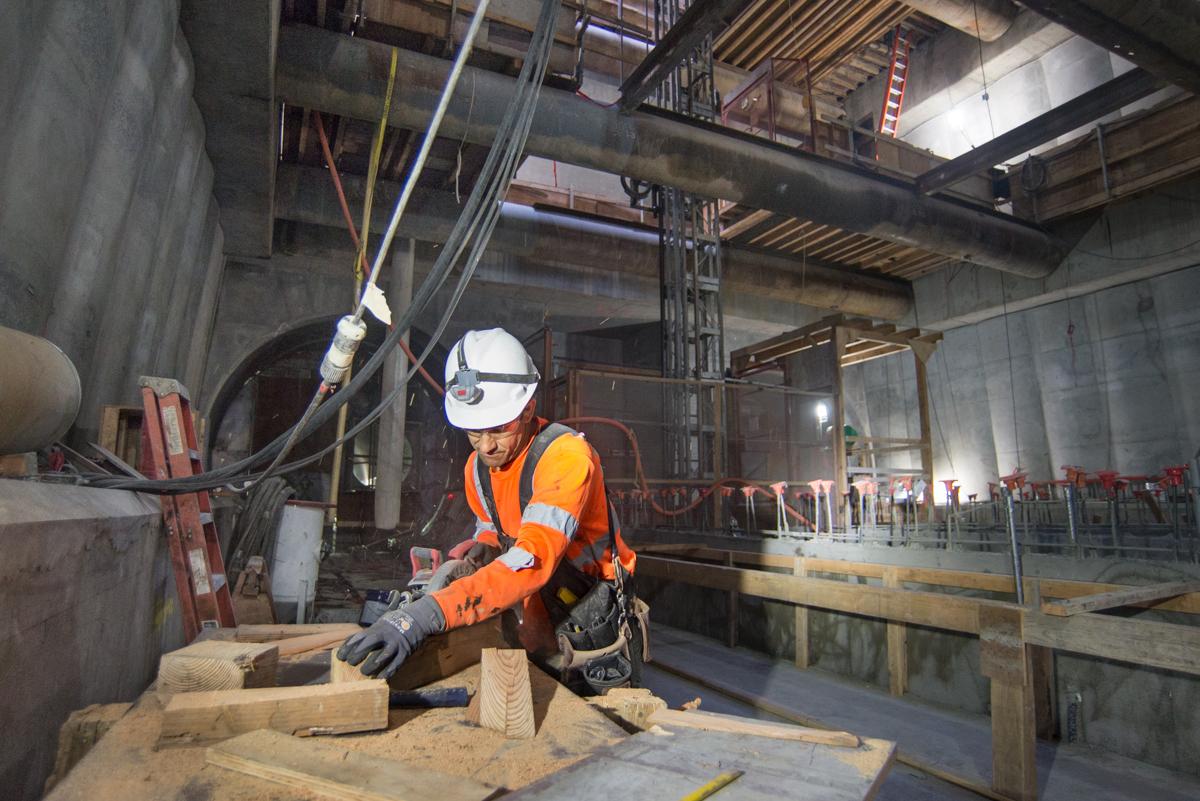 Worker in safety gear constructing concrete formwork for Union Square/Market Street Station platform.