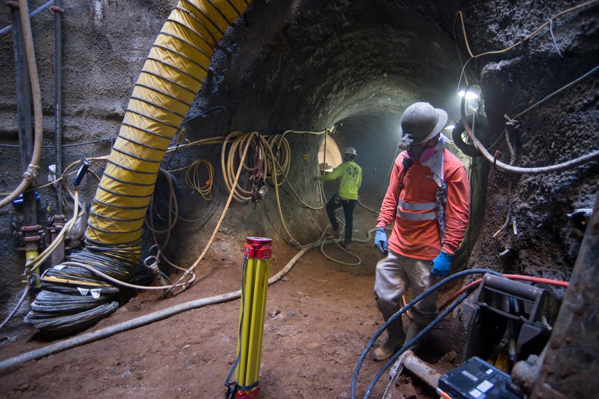Workers in safety gear inside underground tunnel during Central Subway construction at Chinatown Station.