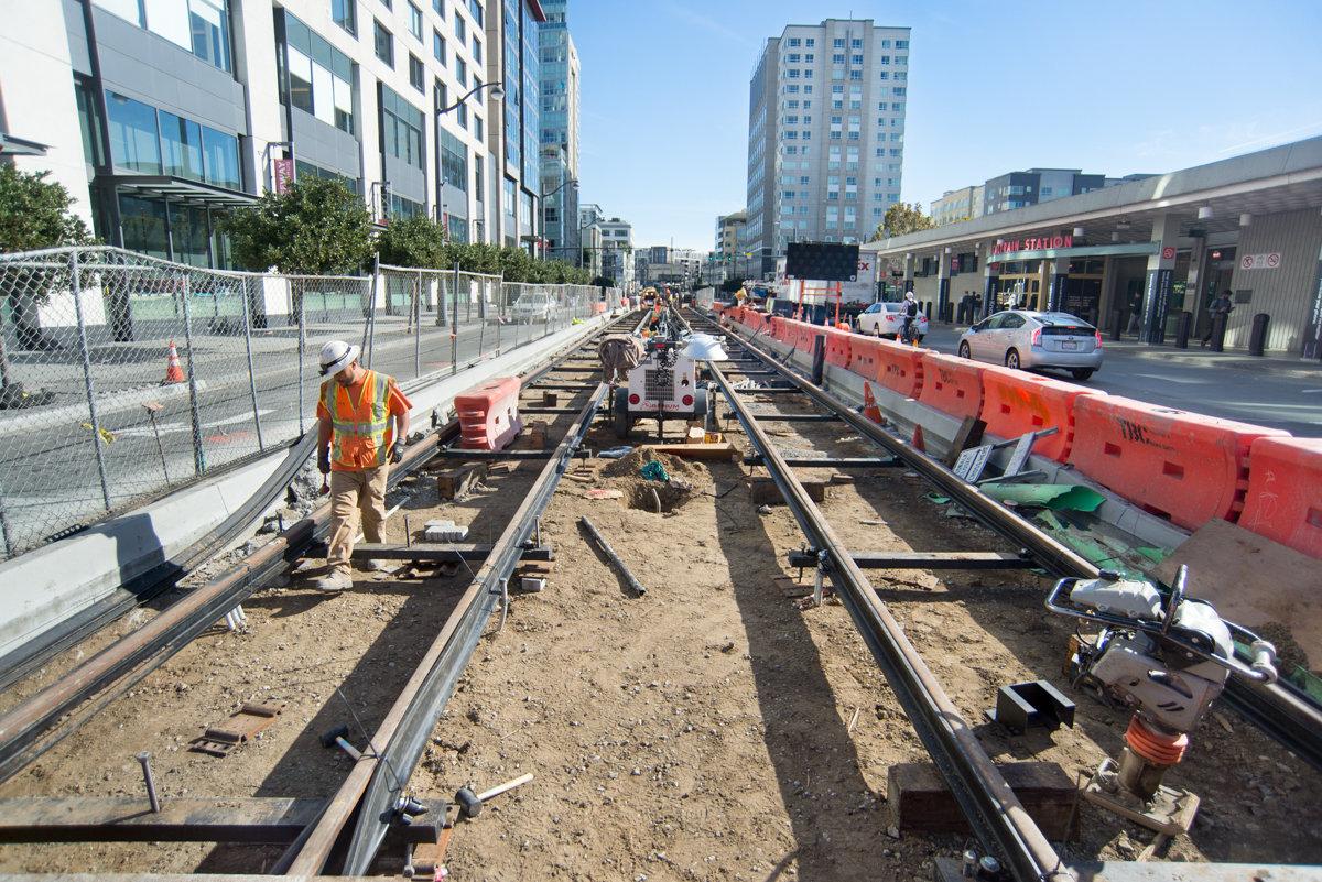 Workers install light rail tracks on 4th Street in San Francisco during Central Subway construction.