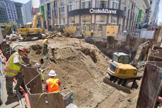 Construction excavation at 4th and O'Farrell Streets with heavy equipment and workers in safety gear.