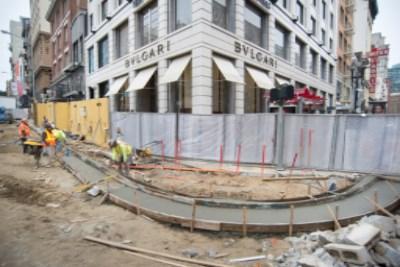 Construction site at Geary and Stockton streets with fencing, equipment, and historic building facade.