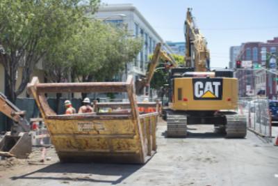 Construction equipment and workers at 4th and Townsend Street during tunnel concrete invert construction.