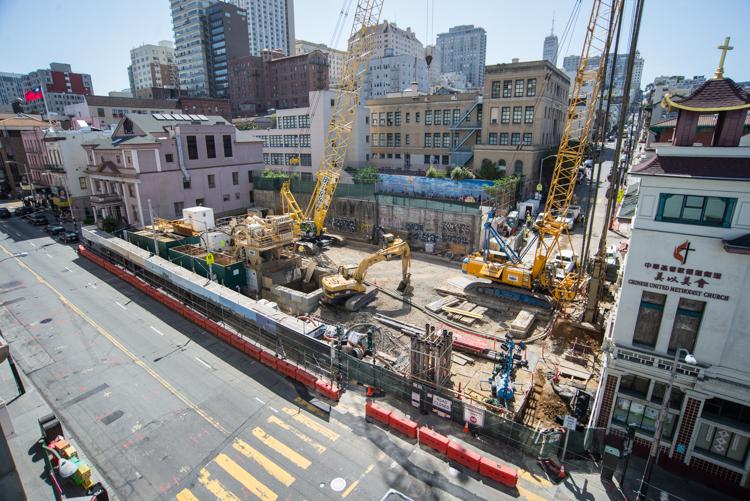 Aerial view of Chinatown Station construction site with heavy equipment, cranes, and barriers along Stockton Street.