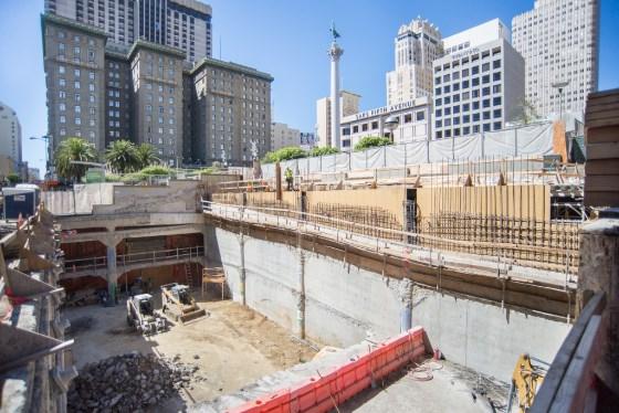 Construction site at 4th Street with concrete barriers, excavation, and downtown buildings visible.