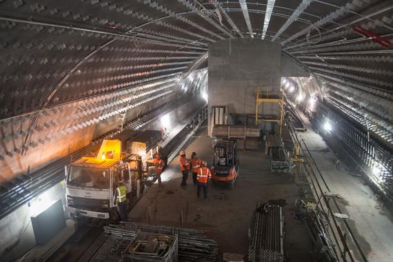 Workers and equipment on Chinatown station platform during construction, viewed from above.