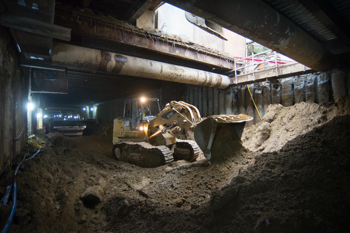 Excavator loading soil from underground station construction onto trucks at Ellis Street access shaft.