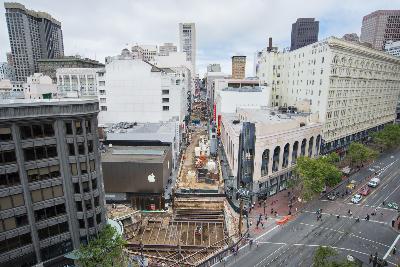 Aerial view of Union Square construction site showing roof deck installation and demolition work along Stockton Street in San Francisco.