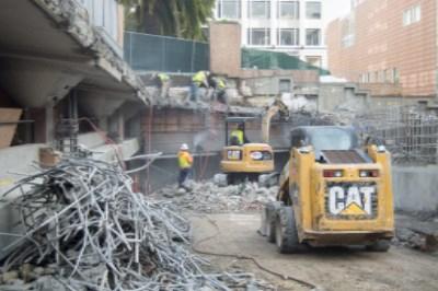Construction crew demolishing Union Square Garage with CAT equipment and rebar removal.