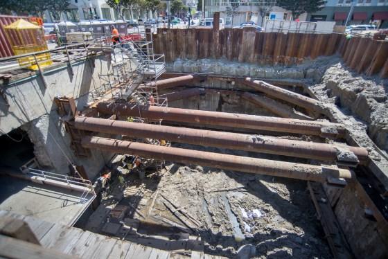 Construction site showing temporary steel support beams spanning across underground transit station headhouse on 4th Street.