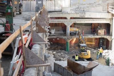 Aerial view of excavation site on Stockton Street with heavy equipment and exposed foundation work.