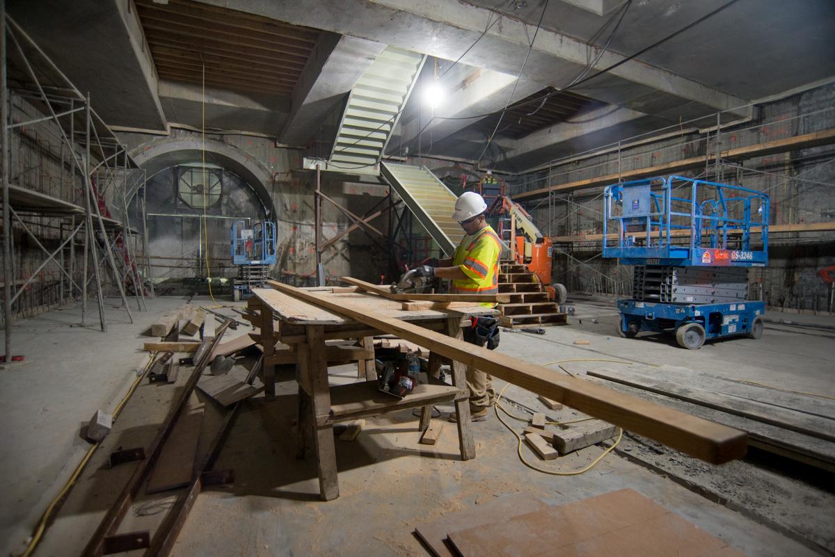 Worker in safety gear operating equipment at Yerba Buena/Moscone station construction site during Central Subway project.