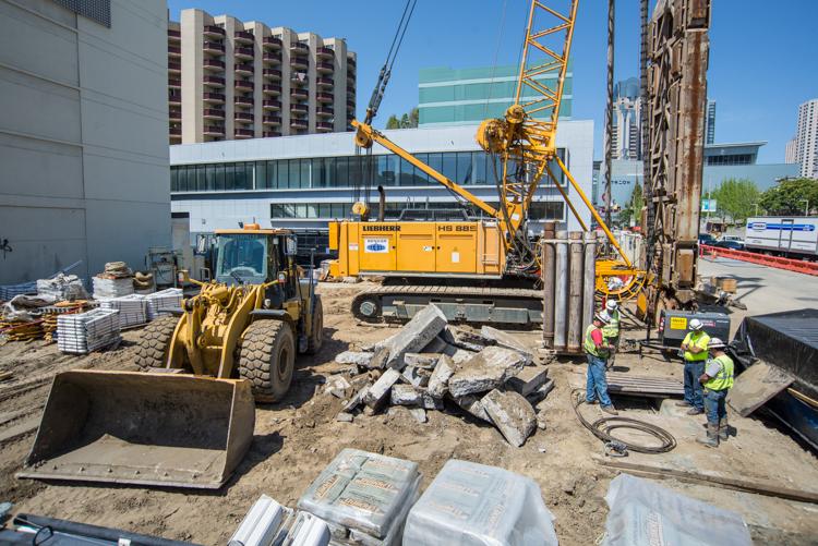 Construction equipment and workers at Yerba Buena/Moscone Station site preparing underground station walls.
