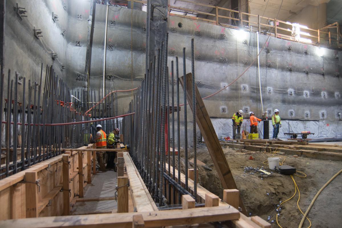 Construction workers install rebar and concrete forms inside an underground station box at Union Square.