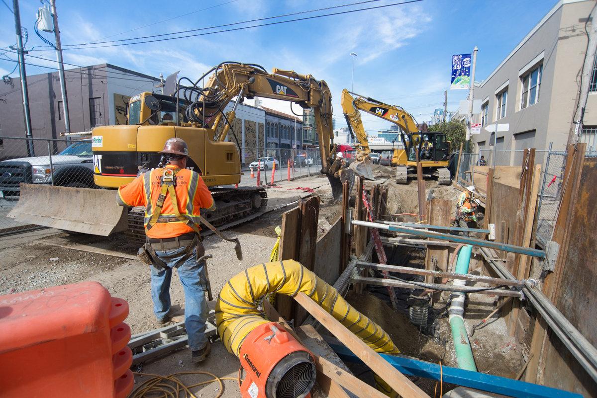 Construction crew installing utilities at 4th and Welsh intersection for Central Subway project