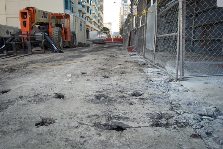 4th Street pothole repair site with orange construction equipment and chain-link fencing