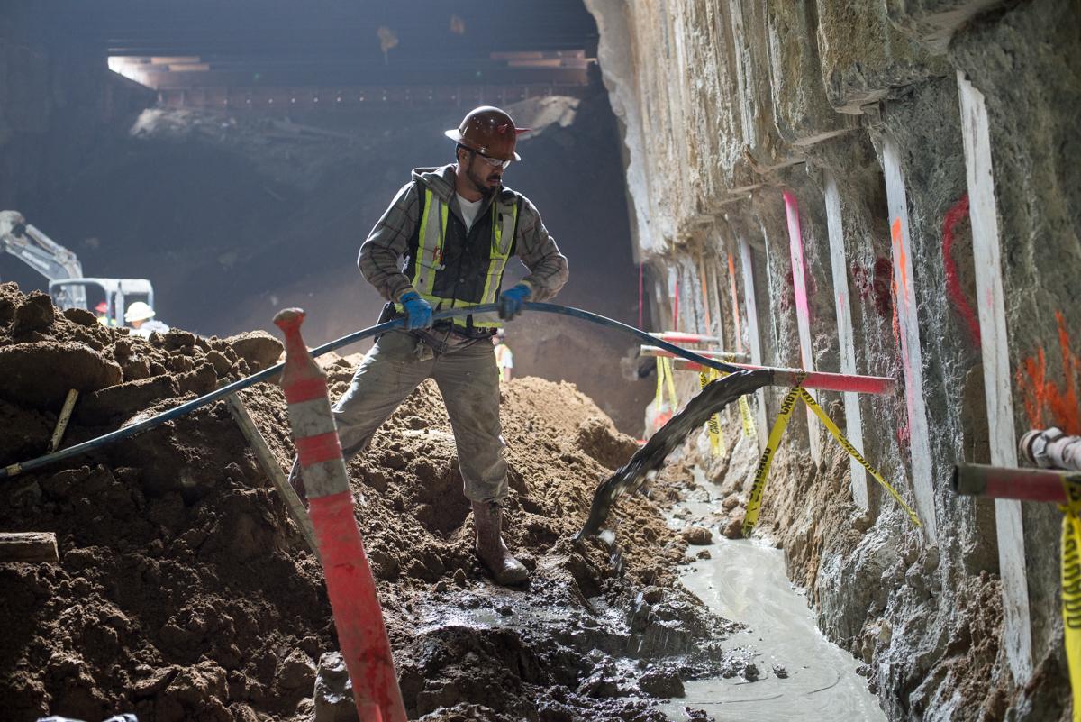 Worker operating soil improvement equipment on Clementina Street construction site.