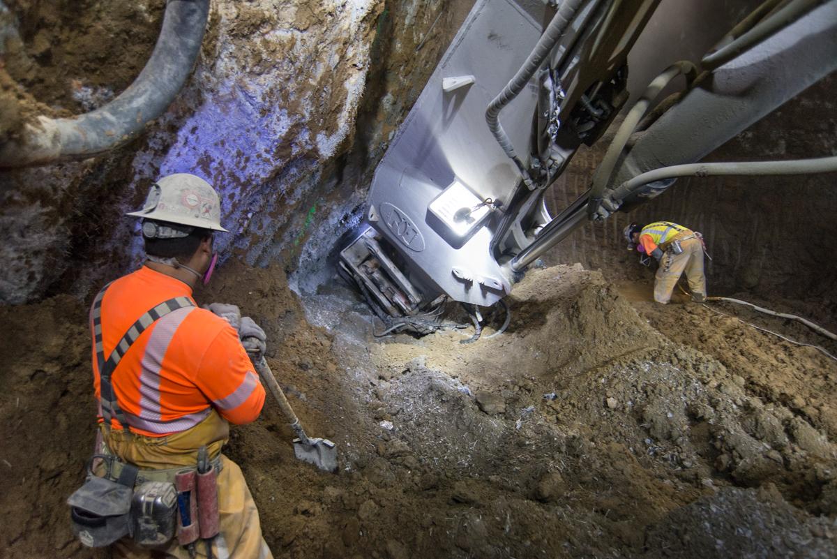 Workers excavate underground utility trench with white truck and heavy equipment on Stockton Street.