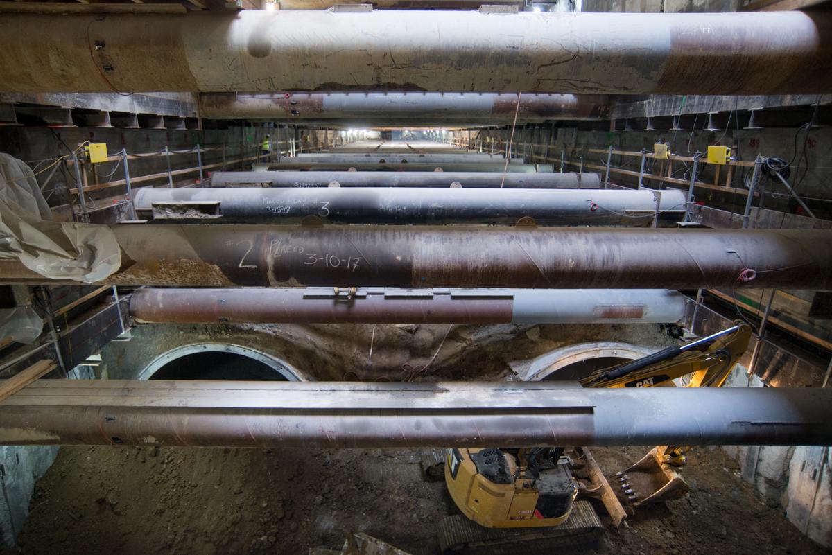 Subway tunnel construction showing stacked cylindrical tunnel segments and excavation equipment during Central Subway project.
