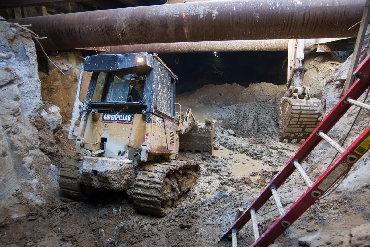 Caterpillar excavator operating in underground construction site beneath Geary Street.