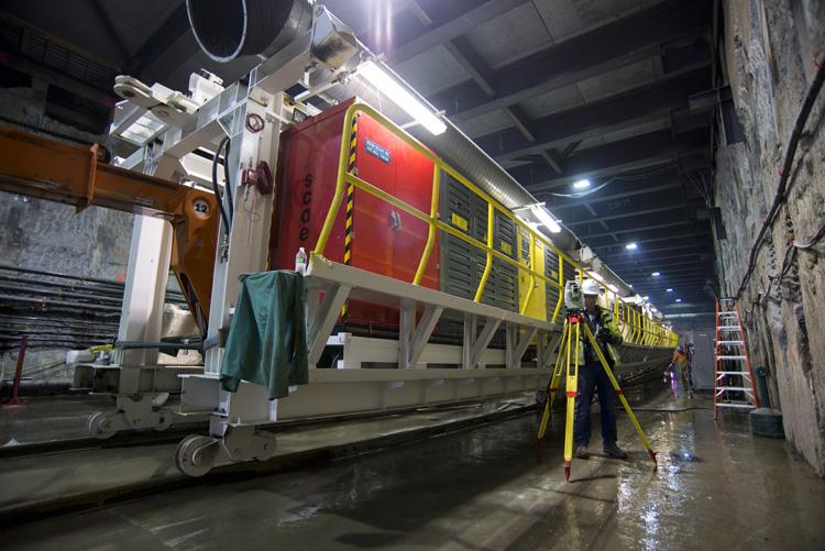 TBM trailing gear positioned on tracks inside tunnel launch box during Central Subway construction.