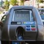 Blue and silver single-space parking meter mounted on street pole with digital display screen.