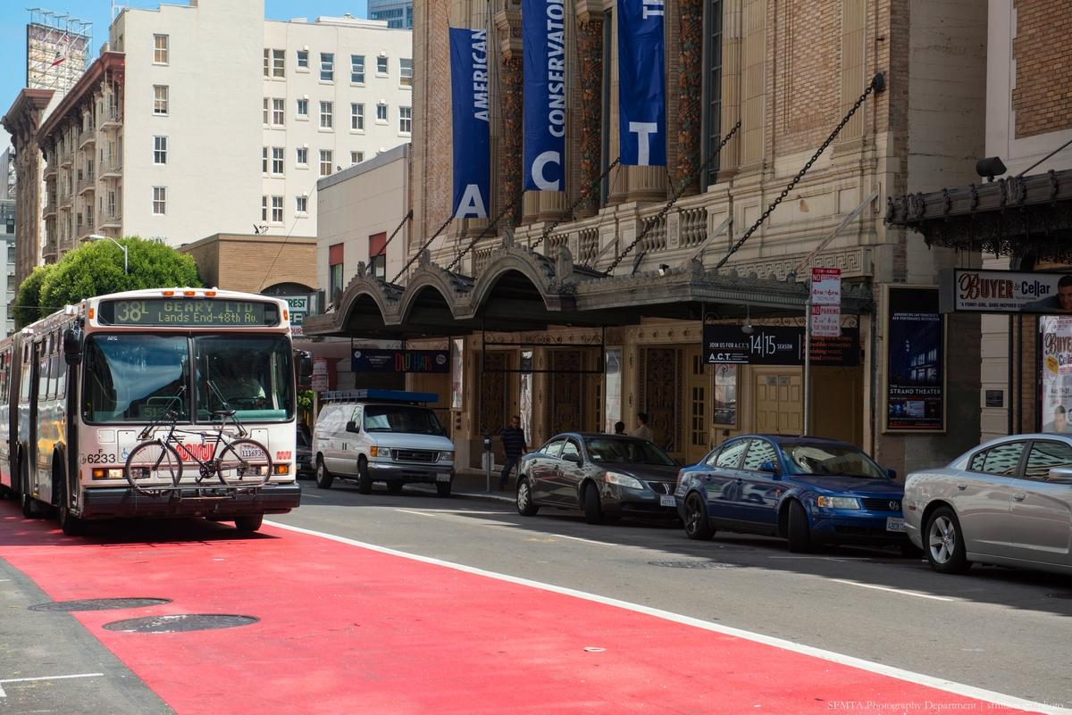 38L Geary bus traveling past the American Conservatory Theatre on a red transit mall lane.