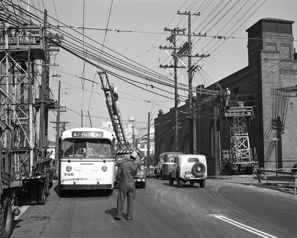 line department crew on ladder trukc above trolley coach