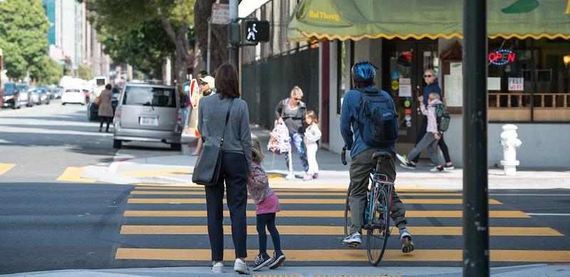 People waiting to cross at the crosswalk.