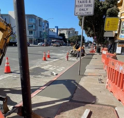 Crews restore the pavement after installation of new underground conduits at Commonwealth Avenue and Geary Boulevard