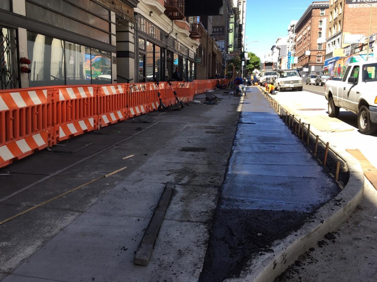 Crews smoothing freshly placed concrete at the inbound bus bulb on O’Farrell between Jones and Taylor streets.