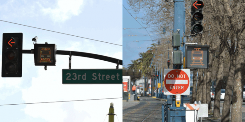 A traffic signal featuring a flashing, filled-in image of a train on tracks attached to a pole beneath a left turn traffic signal and above a "Do Not Enter" sign.