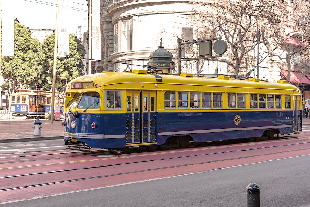 Color photo of streetcar 1010 painted blue and yellow on Market and Powell Streets.