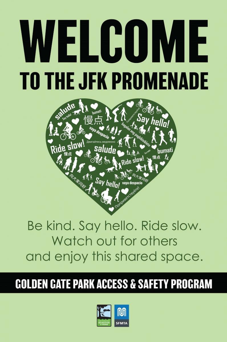 A pale green sign with a dark green heart in the middle. The sign reads Welcome to the JFK Promenade. Inside of the heart, the phrases “ride slow!” and “say hello!” are printed and translated into English, Russian, Tagalog, Spanish, and Chinese. Also inside the heart are silhouettes of park users, including people in wheelchairs, people pushing strollers, people walking, rollerskaters, kids, and cyclists. Underneath the heart, green text reads: “Be kind. Say hello. Ride slow. Watch out for others
