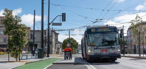 Senior Passenger Steps onto Kneeler Bus Wheelchair user wheels away from Muni bus