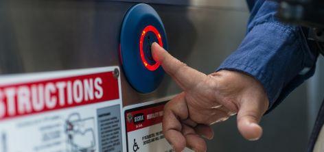 A passenger pushes the Accessible Stop Request button on a Hybrid Bus Passenger pushing the Accessible Stop Request button on a Muni bus