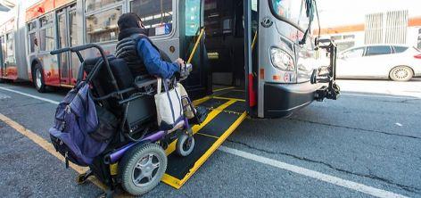 A passenger in a wheelchair uses a low-floor hybrid bus ramp A passenger in a wheelchair uses a low-floor Muni bus ramp