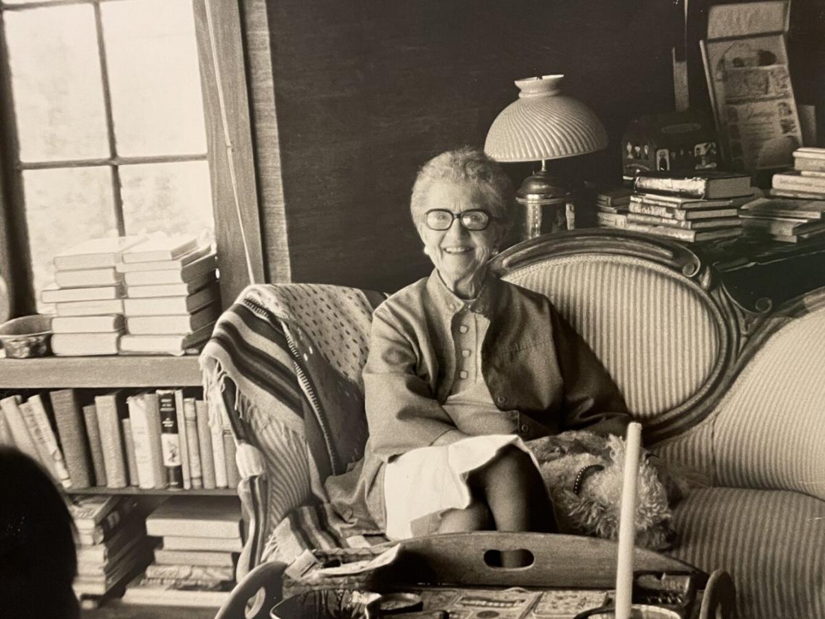 A black and white photo of Friedel Klussman, an activist who fought to save the cable cars. She smiles from a couch in a living room.