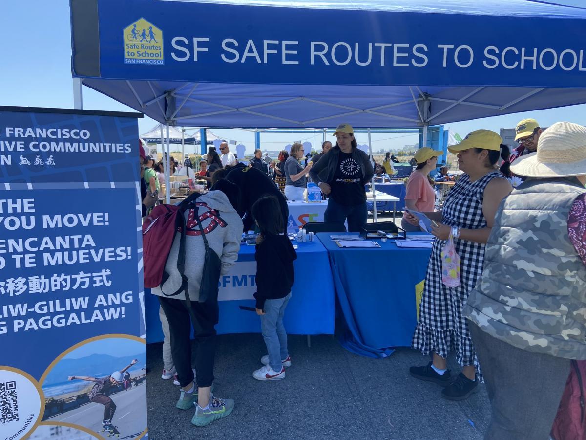SFMTA staff at a festival tent talking to event participants