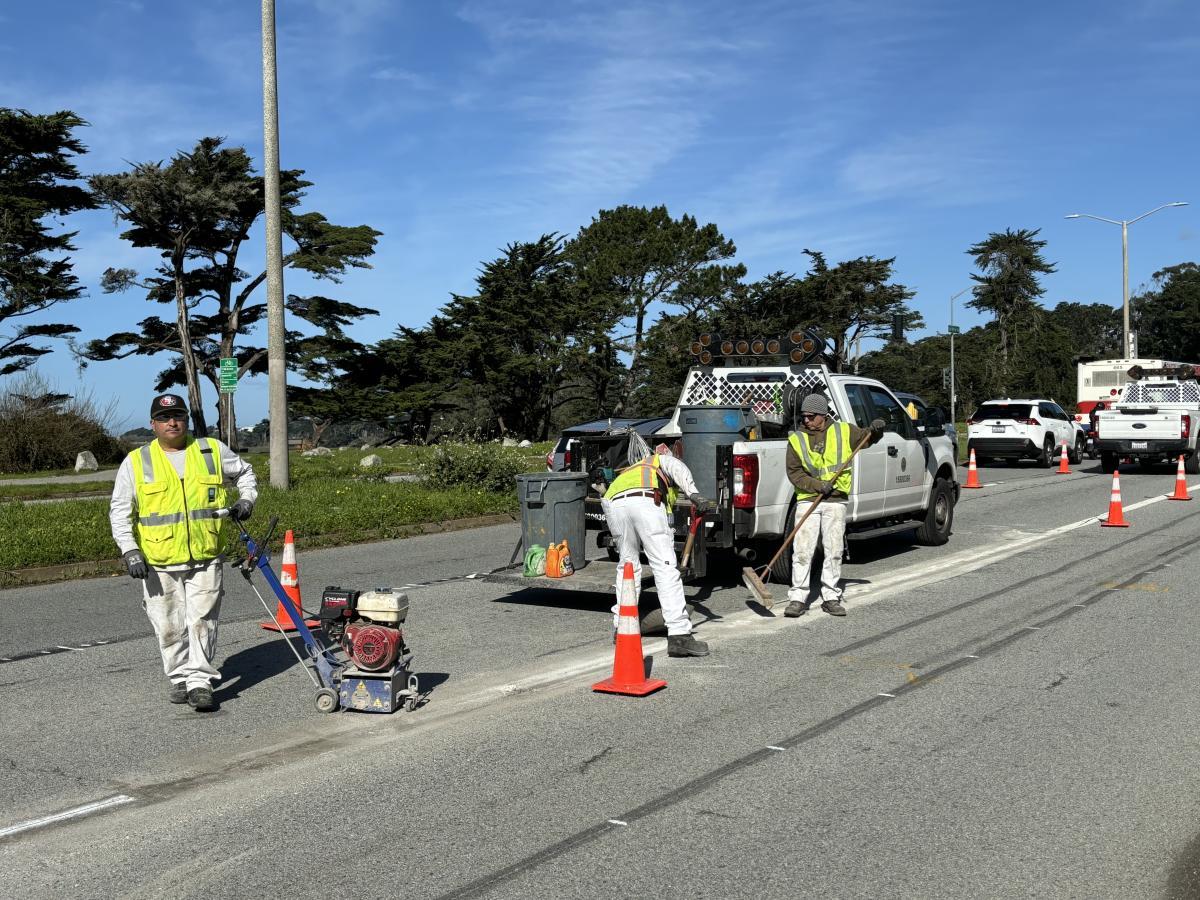 A group of men in safety vests on a road