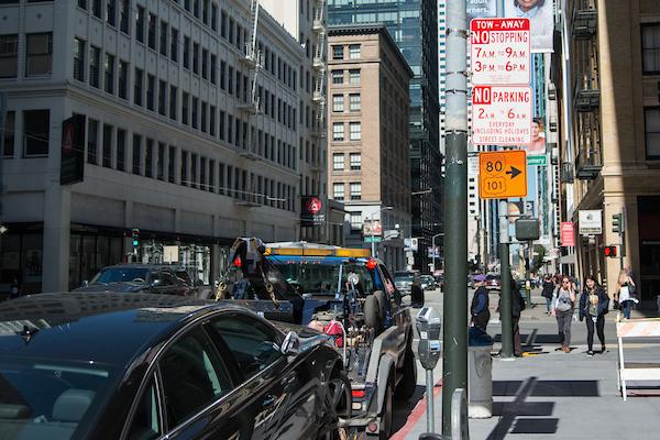 Photo of a tow truck taking away an illegally parked vehicle
