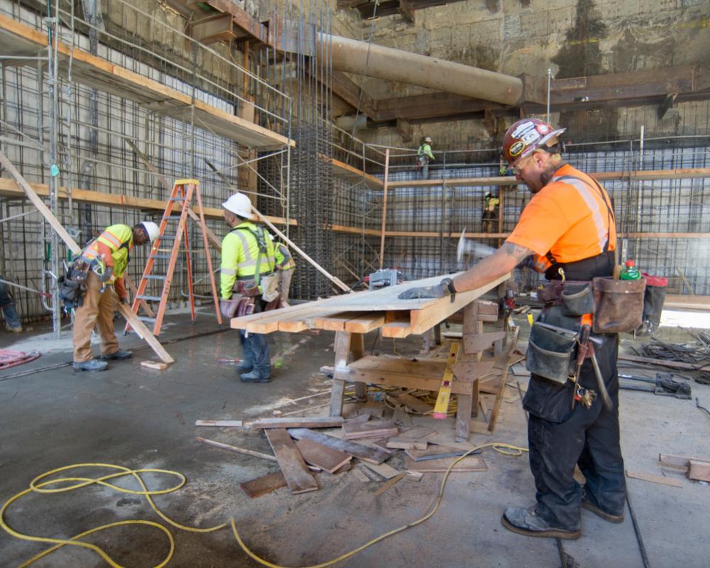 A carpenter builds part of a concrete form in the northwest corner of the YBM station headhouse.