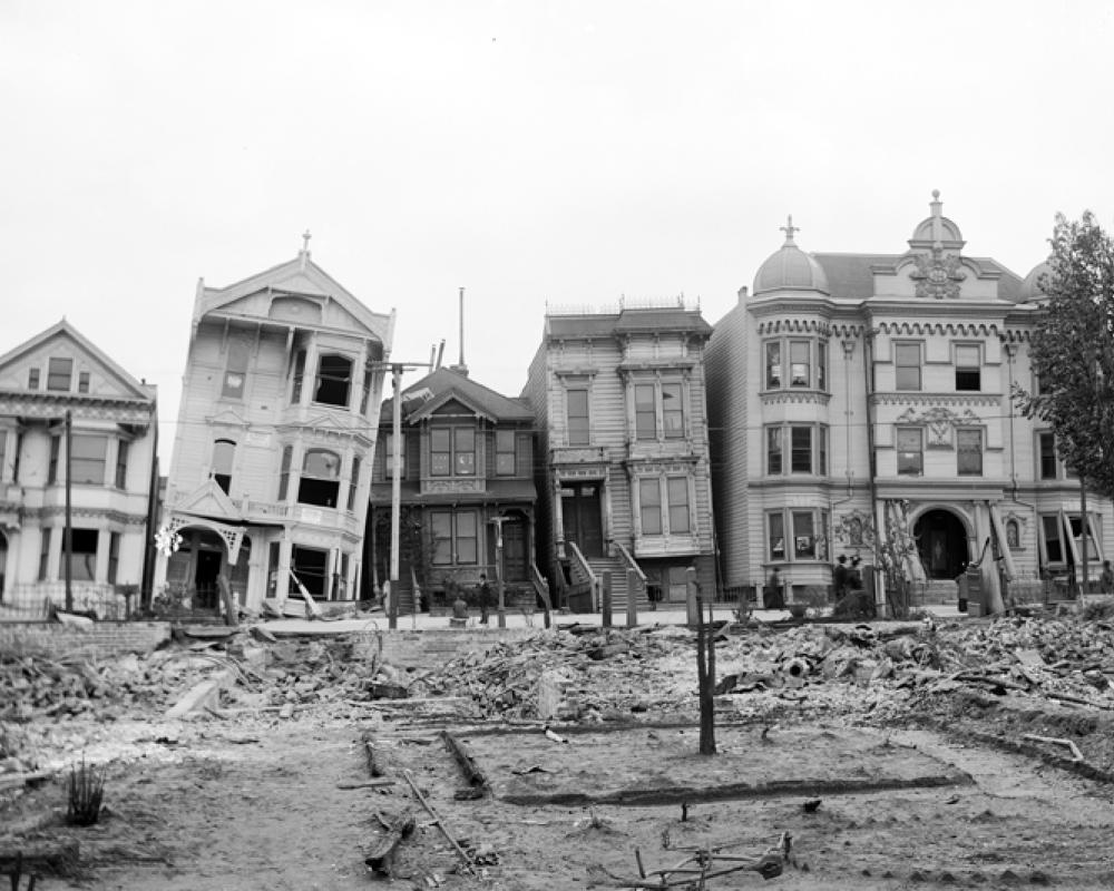 black and white photo of houses damaged and leaning after the 1906 earthquake and fire