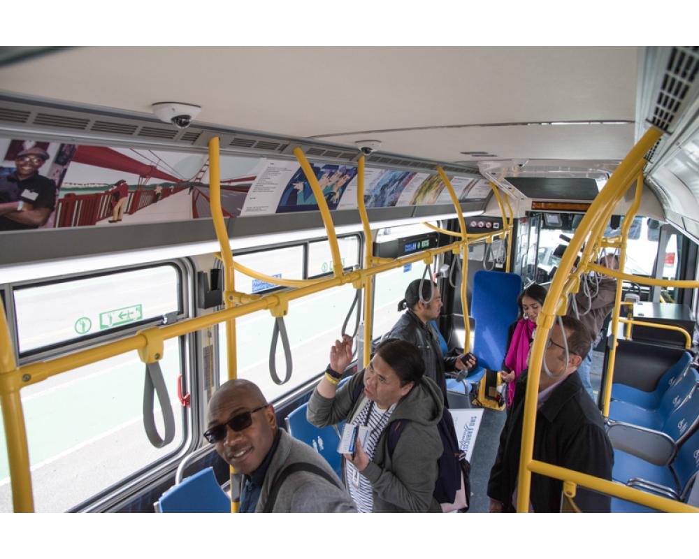 People viewing Muni Art installed in a bus.