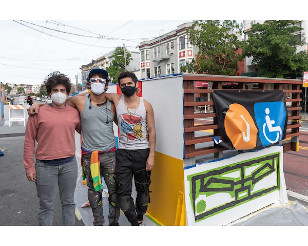 Simón Malvaez with friends in front of his mural "Them (Ramp)"