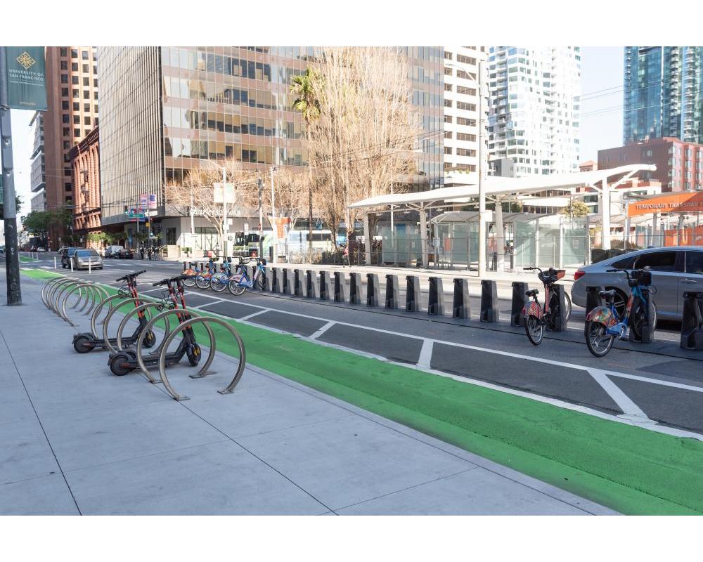bike racks on the sidewalk, protected bikeway, and bikeshare station