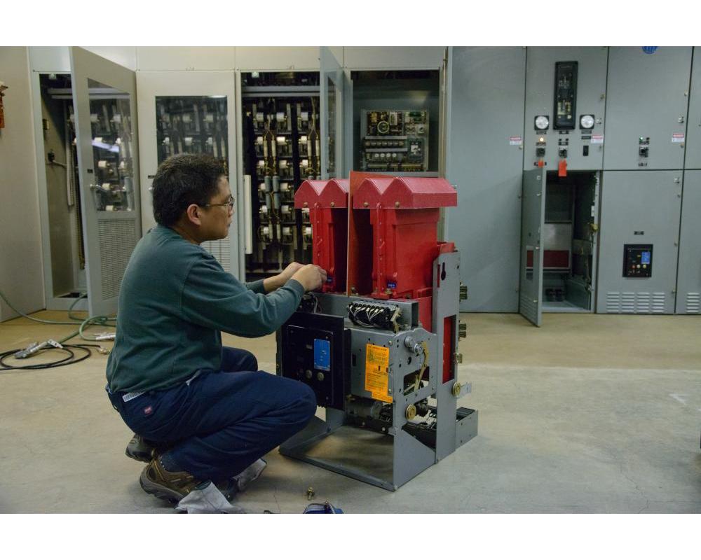 A man is kneeling in front a deck system piece inside a shops location.