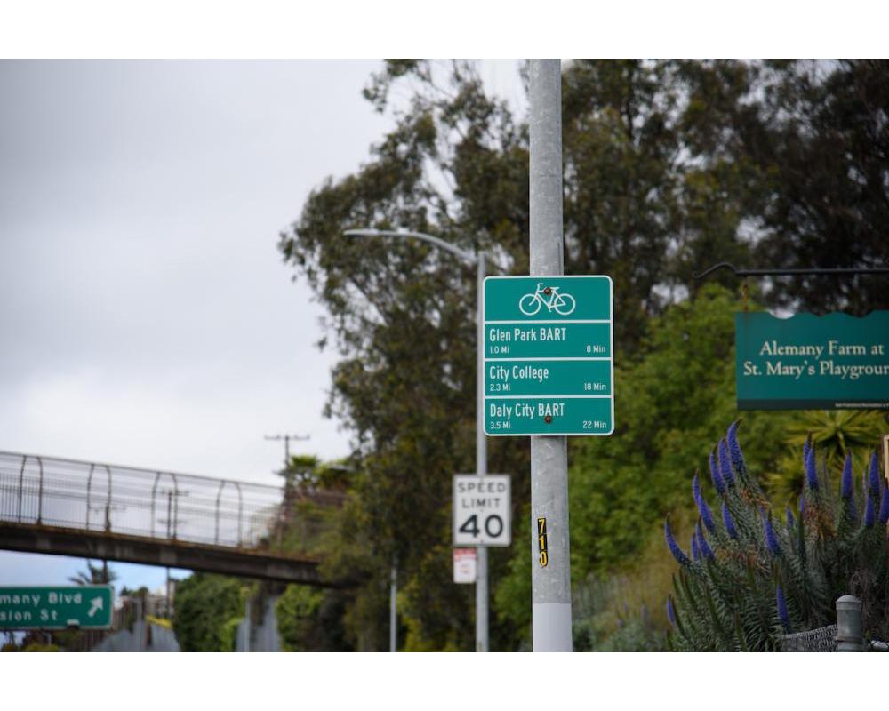 Directional bike signage, 40 MPH sign, and  St. Mary's Park Footbridge