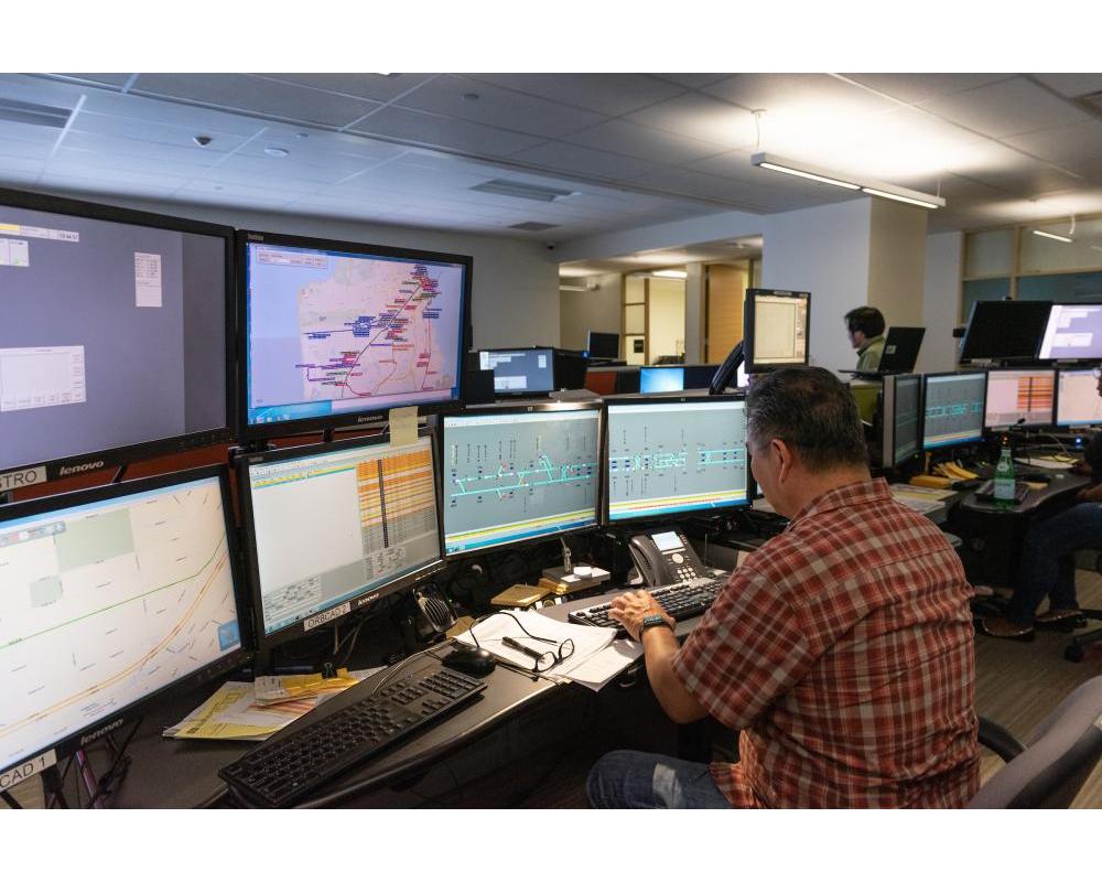 Man sitting at multiple 2010s-era computer monitors