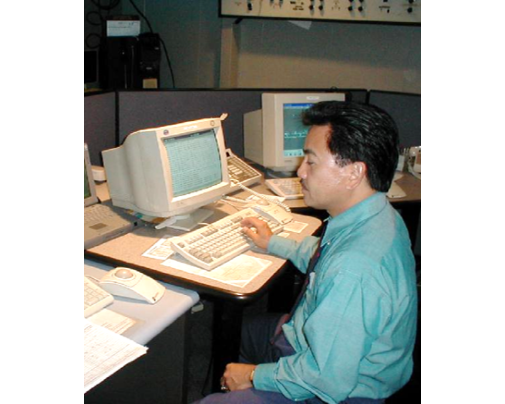 Man sitting at an 1990s-era computer.
